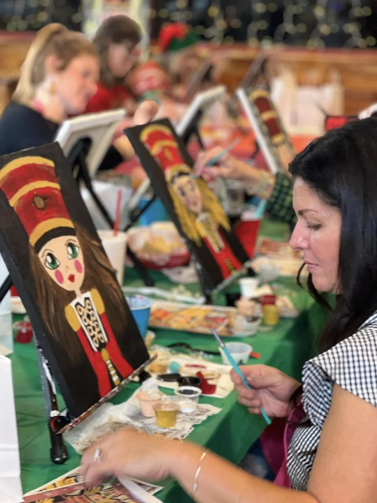 A guest working on her chosen nutcracker design at a paint session table