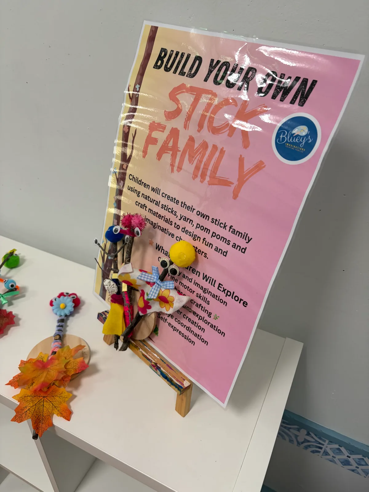 A hands-on stick family craft display made by children at a creative art and craft workshop