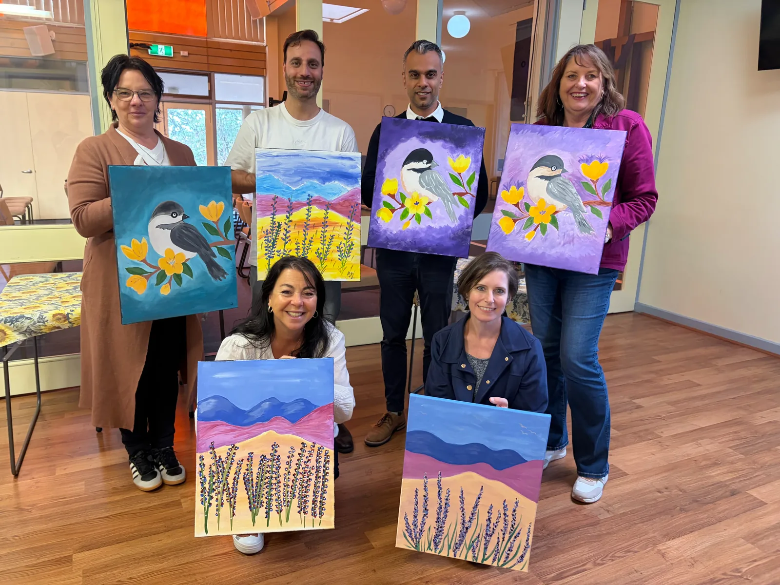 A group of guests holding up the canvases they finished at a Bluey's Imaginations art workshop in Endeavour Hills